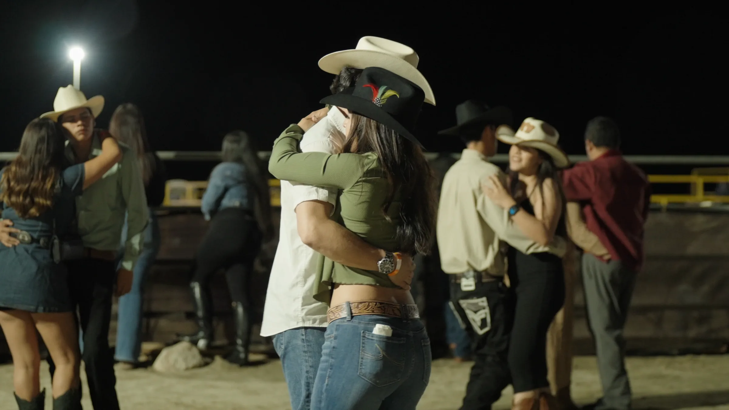 Couples dancing beside the arena during the nighttime event