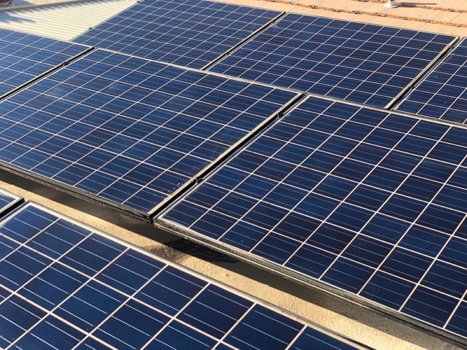 Technician cleaning rooftop solar panels on a Coachella Valley home